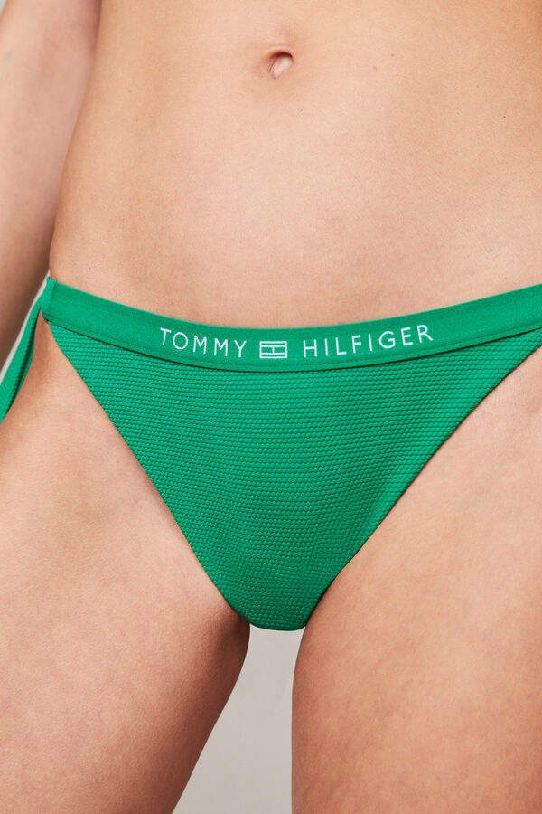 Womensecret Chama a atenção com esta parte inferior de biquíni com laços clássicos na lateral, corte atrevido e com o logo com a assinatura da Tommy Hilfiger na parte da frente. verde